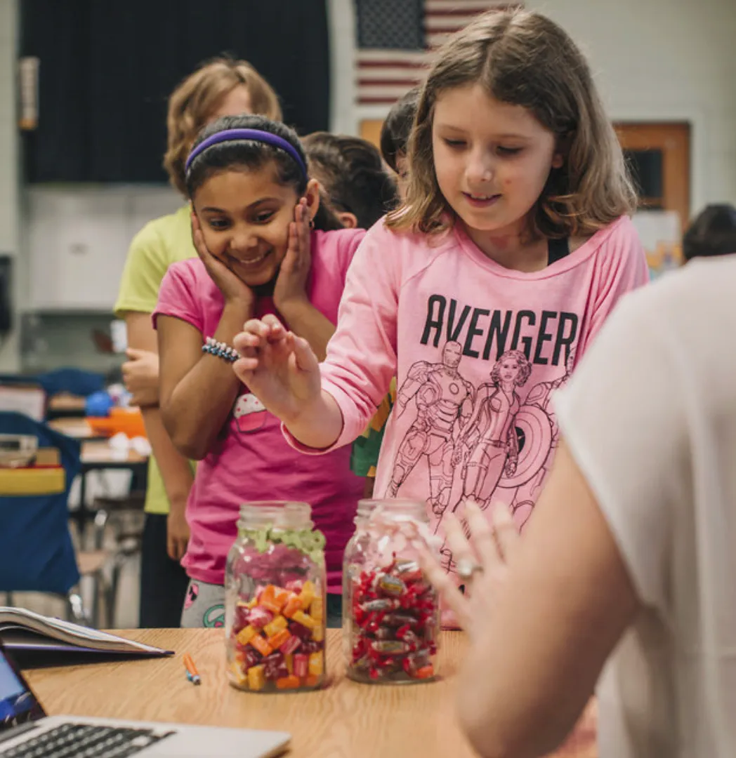Students choosing candy rewards from jars